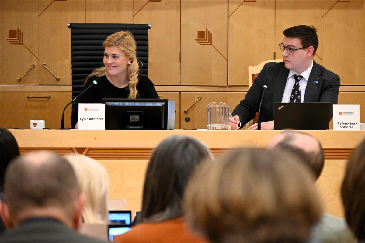 En kvinne og en mann sitter bak et møtelederbord. Foto.  - Klikk for stort bilde